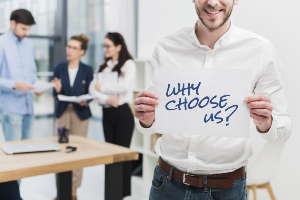 Business Man Holding Paper With Why Choose Us Question 1024x683
